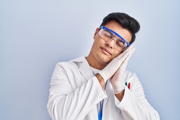 Hispanic man working as scientist sleeping tired dreaming and posing with hands together while smiling with closed eyes.