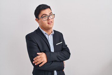 Young hispanic man with down syndrome wearing business style smiling looking to the side and staring away thinking.