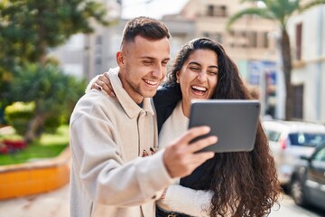 Man and woman smiling confident using touchpad at park
