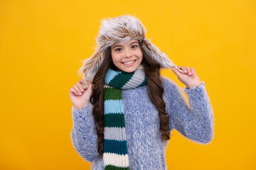 School girl in winter clothes and warm hat. Winter holiday vacation. Child fashion model. Happy face, positive and smiling emotions of teenager girl.