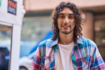 Young hispanic man smiling confident standing at street