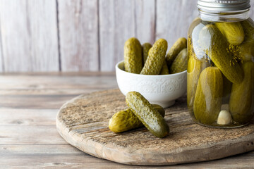 A jar of homemade dill pickles with a bowl full and pickles in front. - Powered by Adobe