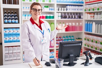 Young beautiful plus size woman pharmacist writing on notebook at pharmacy