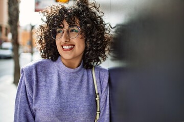 Young middle east woman smiling confident wearing glasses at street
