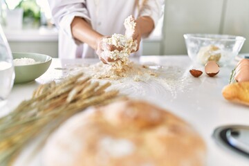 Obraz na płótnie Canvas Young woman wearing cook uniform kneading flour at kitchen