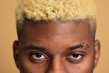 Close up shot of a young black man's skin. Face care concept. Macro studio shot on a beige background.