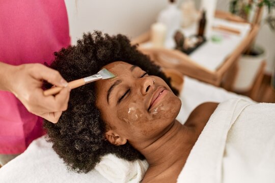 Young African American Woman Having Facial Treatment At Beauty Center