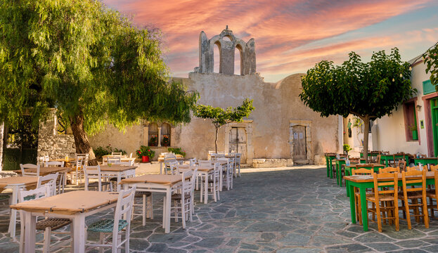 A square with restaurants and old church building in beautiful Chora town on Folegandros Island, Cyclades, Greece.