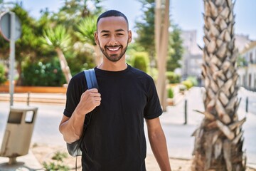 Young african american man smiling confident wearing backpack at park