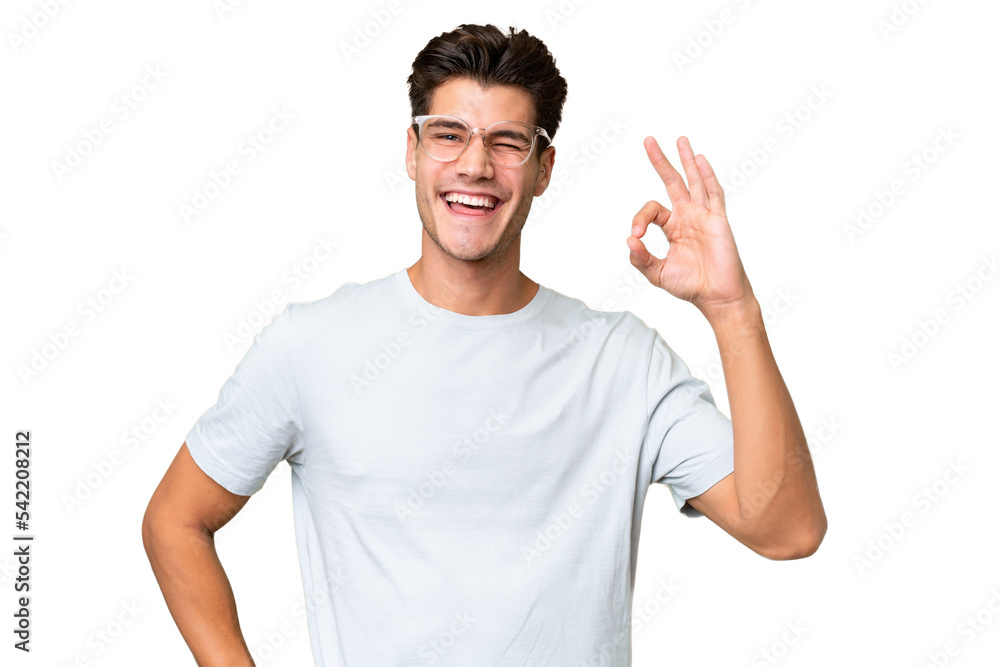 Sticker Young caucasian handsome man over isolated background showing ok sign with fingers