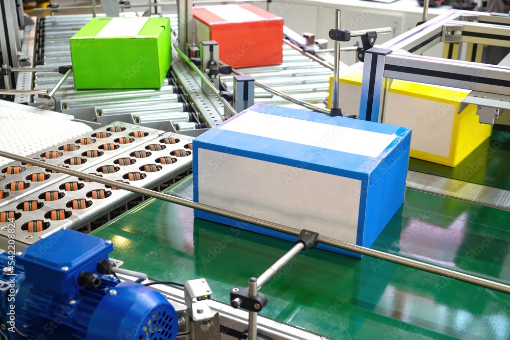 Poster automated production. conveyor line with colorful boxes. production line close up. concept packaging