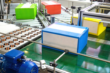 Automated production. Conveyor line with colorful boxes. Production line close up. Concept packaging production line in enterprise. Conveyor tech. Conveyor belt with automated distribution process - obrazy, fototapety, plakaty