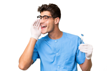 Young dentist man holding tools over isolated background shouting with mouth wide open to the side