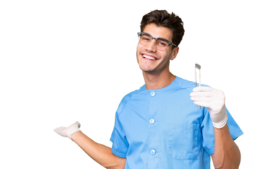 Young dentist man holding tools over isolated background extending hands to the side for inviting to come