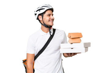 Young caucasian man with thermal backpack over isolated background looking side