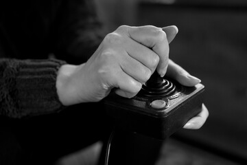 Woman playing old retro console with joystick.