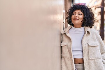 Young beautiful hispanic woman smiling confident looking to the side at street