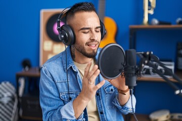 Young hispanic man artist singing song at music studio