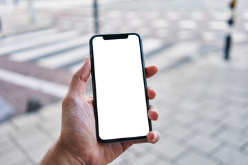 Man holding smartphone showing white blank screen at street