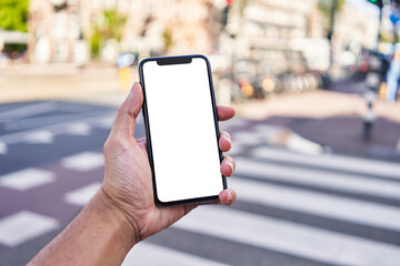 Man holding smartphone showing white blank screen at street