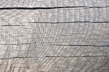Old gray cracked weathered washed tainted wood texture with horizontal cracks with traces of sawn down. Natural textured closeup dry plank background.