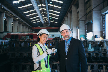 Portrait of Professional Engineers express a high level of confidence and shake hand at the railway garage.