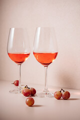 Two glasses of rose wine and red grapes.