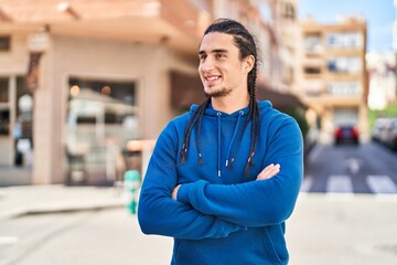 Obraz premium Young man smiling confident standing with arms crossed gesture at street