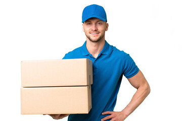 Delivery caucasian man over isolated background posing with arms at hip and smiling