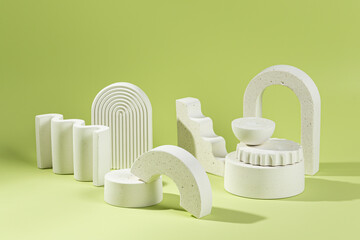 An empty stage with a composition of white podiums of different sizes and shapes on a green background and shadows