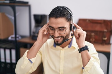 Young arab man call center agent smiling confident working at office