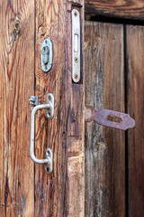 Old wooden door with metal locks and handle