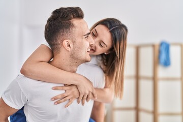 Man and woman couple holding on back standing at bedroom