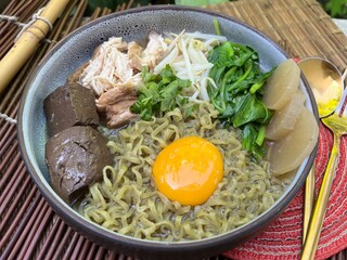 Vegetable noodles and chicken soup with yolk