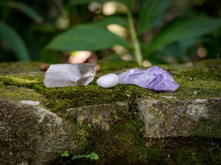 Selective focus shot of crystal minerals on a mossy rock surface