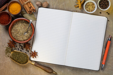 Cooking spices used to add flavor and seasoning with an open recipe book with blank pages - space for text.