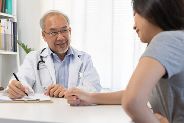 Close up doctor talking with the patient at a desk in the clinic