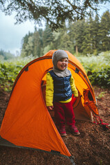 Child hiking with camping tent travel family vacation outdoor in forest adventure lifestyle happy smiling emotional 2 years old kid