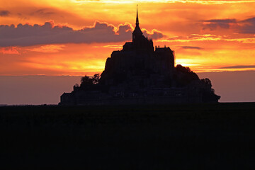 Romantic sunset sky and dark silhouette of Mont Saint Michel Abbey in Normandy France