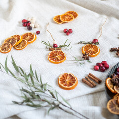 Natürliche Dekoration für Weihnachten mit getrockneten Orangenscheiben, Zimt, Cranberry, Anis und Eukalyptus, Weihnachtsdeko im Scandi-Look minimalistisch gestaltet
