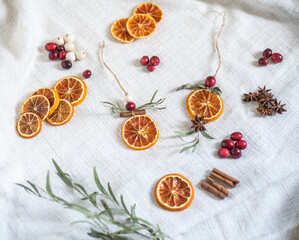 Natürliche Dekoration für Weihnachten mit getrockneten Orangenscheiben, Zimt, Cranberry, Anis und Eukalyptus, Weihnachtsdeko im Scandi-Look minimalistisch gestaltet
