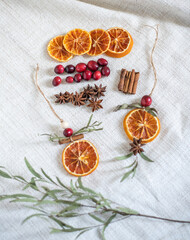 Fototapeta na wymiar Natürliche Dekoration für Weihnachten mit getrockneten Orangenscheiben, Zimt, Cranberry, Anis und Eukalyptus, Weihnachtsdeko im Scandi-Look minimalistisch gestaltet 