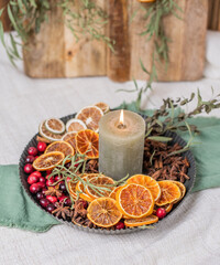 Natürliche, rustikale Dekoration mit getrockneten Orangenscheiben aus Holzbrett, Weihnachtsdeko im Scandi Look mit Kerzen, dekorieren für den Advent