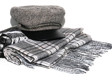 Cap lies on warm gray scarves close-up