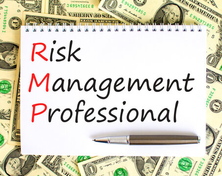 RMP risk management professional symbol. Concept words RMP risk management professional on white note on a background from dollar bills. Business RMP risk management professional concept. Copy space.