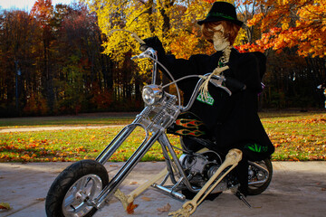Skeleton biker sitting on a motorcycle during autumn color tours