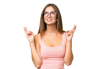 Young pretty woman over isolated background with fingers crossing and wishing the best