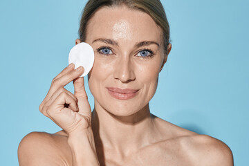 Makeup and removal skin care and cleansing. Beautiful woman with cosmetic cotton pad near her face taking care of skin