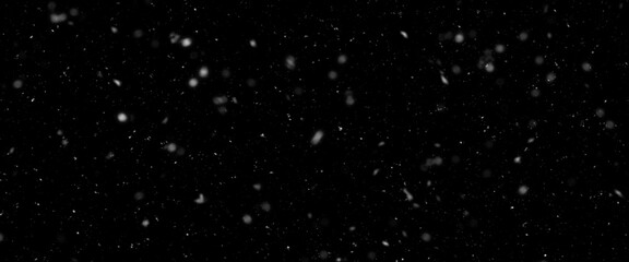 Falling snow isolated on black background. Falling snow at night. Bokeh lights on black background, flying snowflakes in the air. Winter weather. Overlay texture.	