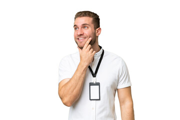 Fototapeta premium Young caucasian man with ID card isolated on green chroma background thinking an idea while looking up